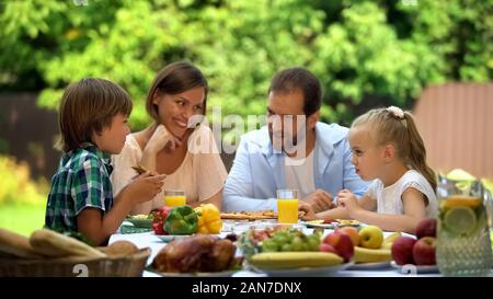 Friendly family traditionnel dîner en plein air, les parents Les enfants heureux ensemble Banque D'Images