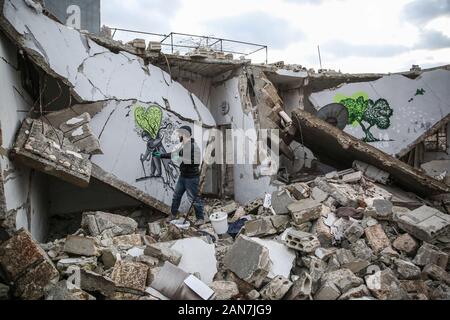 Kafr Nabî, la Syrie. 13Th Jan, 2020. Une photo disponible le 16 janvier 2020 montre l'artiste syrien Abu Malik Al-Shami dessiner une fresque graffiti sur le mur d'un bâtiment qui a été détruit dans un bombardement. Al-Shami a commencé à peindre des murales retour en 2014 sur les murs de l'a détruit des bâtiments de sa ville natale assiégée puis de Darayya, situé à au sud-ouest de Damas. Après son déplacement, l'artiste a continué à peindre des murales à Idlib pour attirer l'attention sur la situation humanitaire catastrophique. Credit : Anas Alkharboutli/dpa/Alamy Live News Banque D'Images