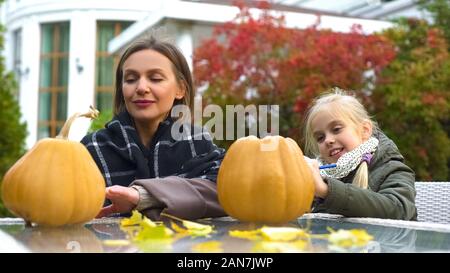 Happy mother and daughter carving pumpkin jack-o-lanterne pour Halloween party Banque D'Images