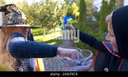 Fille et garçon joyeux en prenant tous les bonbons, voisin de l'halloween sur Halloween Banque D'Images