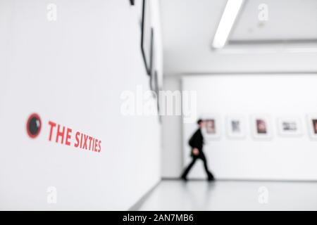 Oberhausen, Allemagne. 16 janvier, 2020. 'Les années 60' se trouve sur un mur alors qu'un visiteur dans l'arrière-plan promenades à travers l'exposition. Conférence de presse sur l'exposition 'Photographe parmi les musiciens : Linda McCartney - les années 60 et plus". Sur l'affichage des photos de Linda McCartney de la scène musicale de la fin des années 60 : Janis Joplin, Jimi Hendrix, Aretha Franklin, les Beatles, les Rolling Stones, et bien d'autres. En outre, l'exposition est consacrée à l'exécution de travaux que la contribution de McCartney soi-disant street photography. Sur l'affichage sont 180 œuvres. Credit : Fabian Strauch/dpa/Alamy Live News Banque D'Images