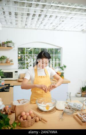 Fissuration femme oeufs dans le bol en verre Banque D'Images