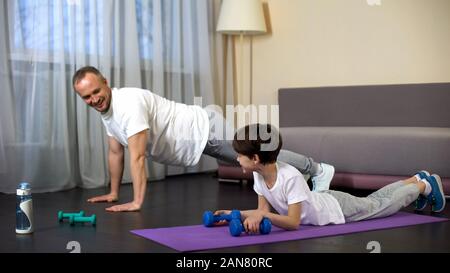 Père et fils faisant d'entraînement à la maison, papa garçon encourageant à former, la motivation Banque D'Images