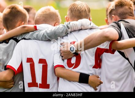 Heureux les enfants dans une équipe sportive. Les joueurs d'un entassement de l'équipe avec l'entraîneur avant le match final du tournoi Banque D'Images