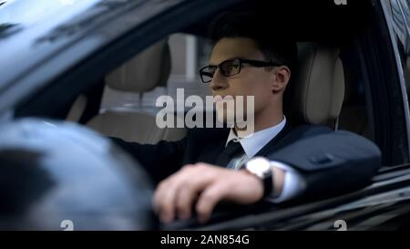 Entreprise sérieuse man sitting in car, l'attente dans la circulation, les transports Banque D'Images