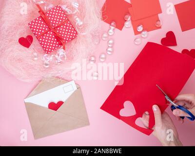 Femme se coupe en feutre rouge coeurs, de l'artisanat pour la Saint-Valentin, la créativité fait main, vue du dessus Banque D'Images