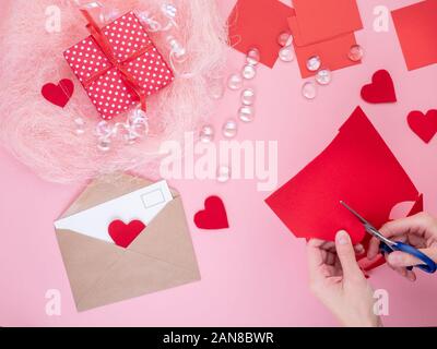 Femme se coupe en feutre rouge coeurs, de l'artisanat pour la Saint-Valentin, la créativité fait main, vue du dessus Banque D'Images