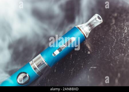 Vape metal stylo cigarette lectronique avec vaping nuage de fume fond  sombre Photo Stock - Alamy