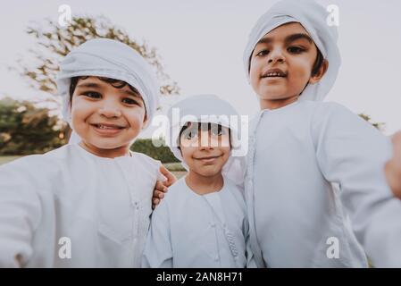 Les enfants jouer ensemble à Dubaï dans le parc. Groupe d'enfants portant des kandura traditionnelle robe blanche de arabes unis Banque D'Images