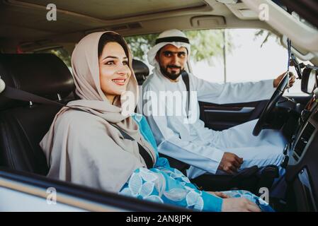 Couple heureux de conduire la voiture à Dubaï. L'homme et de la femme de sortir pour faire du shopping. Concept de relation dans les eau Banque D'Images