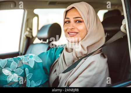 Belle femme dans le port de Dubaï abaya robe traditionnel des femmes de conduire la voiture. Concept à propos des droits des femmes et des eau Banque D'Images