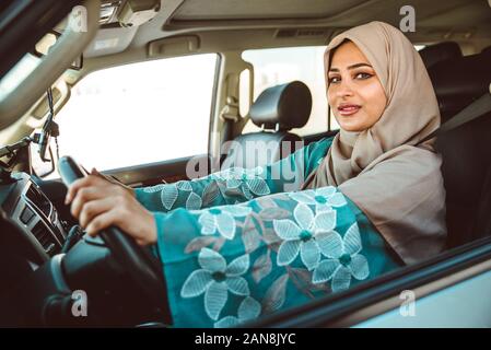 Belle femme dans le port de Dubaï abaya robe traditionnel des femmes de conduire la voiture. Concept à propos des droits des femmes et des eau Banque D'Images