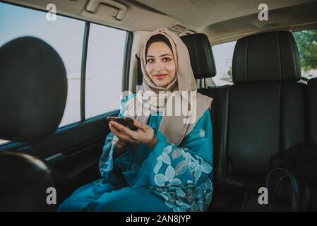 Belle femme dans le port de Dubaï abaya robe traditionnel des femmes de conduire la voiture. Concept à propos des droits des femmes et des eau Banque D'Images