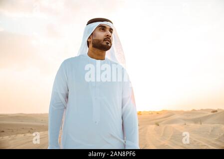 Les hommes d'affaires des eau traditionnelles kandura blanche passer du temps dans le désert de Dubaï Banque D'Images