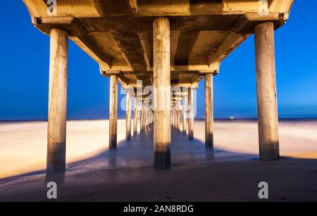 Sous Huntington Beach pier en Californie du sud pendant la nuit, une longue exposition de flou ocean Banque D'Images