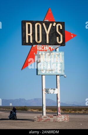 Amboy, Route 66, USA - 27 Avril 2013 : Motorcyclist parking à Vintage signe pour Roy's motel et cafe à Amboy, en Californie. Butée latérale de la route célèbre Banque D'Images