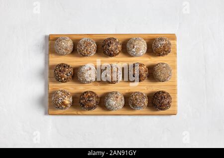 Des boules d'énergie avec les abricots secs, les raisins secs, les dattes, les pruneaux, noix, amandes et noix de coco. Une saine. Mise à plat, vue du dessus. Banque D'Images