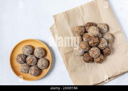 Des boules d'énergie avec les abricots secs, les raisins secs, les dattes, les pruneaux, noix, amandes et noix de coco. Une saine. Mise à plat, vue du dessus. Banque D'Images