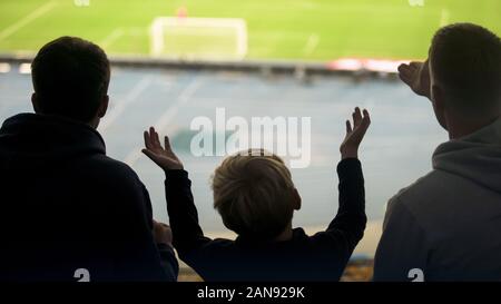 Garçon avec des frères émotionnellement regarder le football à stade, excité avec game Banque D'Images