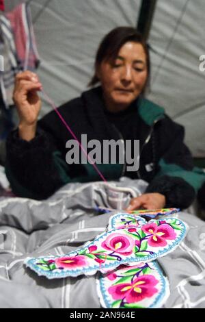 (200116) -- XAYAR , 16 janvier 2020 (Xinhua) -- Li fait Cunzhi semelles brodées dans son dortoir après le travail dans le désert Taklimakan, nord-ouest de la Chine, la Région autonome du Xinjiang Uygur, 14 janvier 2020. L'exploration d'huile de BGP travailleurs Inc., China National Petroleum Corporation, dont plus de 60 sont des femmes, sont engagés dans un travail acharné dans le désert Taklimakan. (Xinhua/Ding Lei) Banque D'Images