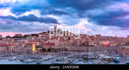 Vue panoramique du Vieux Port et de la Basilique Notre Dame de la garde sur l'arrière-plan sur la colline au coucher du soleil, Marseille, France Banque D'Images