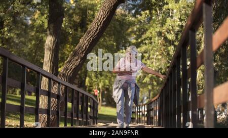 Senior woman running in park, la souffrance, le chagrin d'un problème de santé à l'âge aîné Banque D'Images