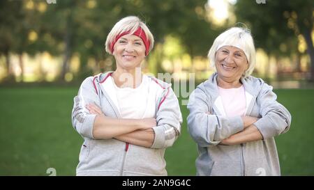 Sourire plein d'énergie mature women posing in park après entraînement, fitness Banque D'Images