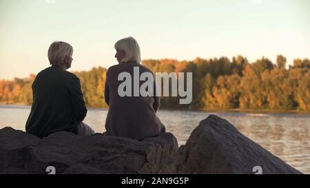 Les femmes adultes parler près du lac dans le parc, profiter de week-end en plein air, loisirs Banque D'Images