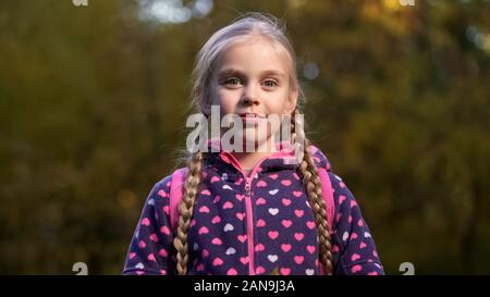 Belle fille d'âge scolaire avec deux tresses smiling and looking at camera Banque D'Images