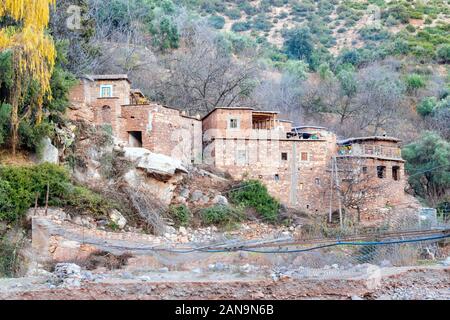 Petit village berbère par River dans l'Atlas, Maroc Banque D'Images