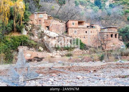 Petit village berbère par River dans l'Atlas, Maroc Banque D'Images