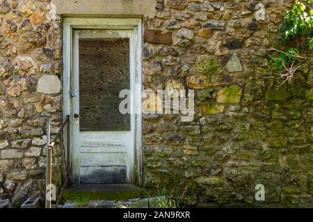 Une porte arrière et mur de pierre d'un vieux bâtiment. Cela a été utilisé comme un garage et station-service à mon grand-père utilisé pour propre et fonctionner dans les années 1950 et encore stan Banque D'Images