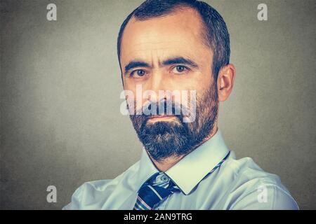 Portrait d'un jeune homme sérieux. Course mixte modèle barbu isolé sur fond gris mur studio avec copie espace. Image horizontale. Banque D'Images