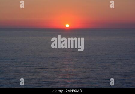 Coucher de soleil sur la mer rouge, la combustion de ciel clair, bleu foncé et l'horizon de surface de la mer Banque D'Images
