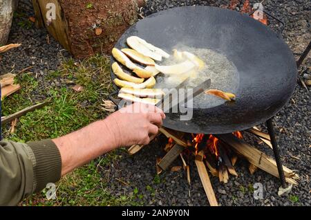 La préparation des repas en plein air, torrefacteur plein de bolets champignons frits dans l'huile profonde Banque D'Images