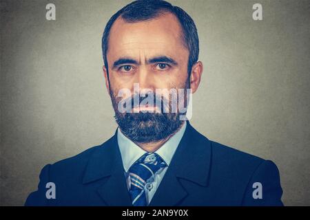 Gros plan Portrait d'un homme mûr d'âge moyen à la caméra à vous au sérieux. Course mixte modèle barbu isolé sur fond gris mur studio Banque D'Images