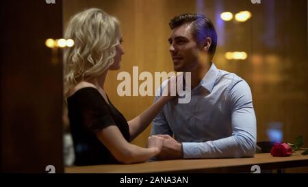 Couple sitting in restaurant et tenir la main, relation romantique, datant Banque D'Images