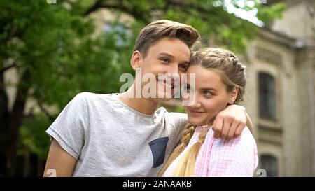 Couple d'adolescents heureux timide enlacés, première relation stagiaire, Banque D'Images