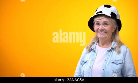 Old woman Smiling funny football hat, modèle pour votre annonce, sport pariant Banque D'Images
