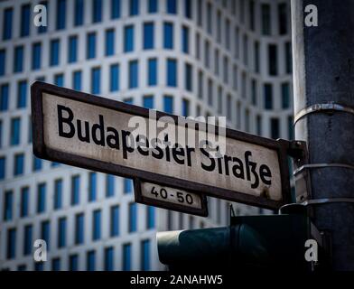 Une photo de gros plan d'un panneau de rue portant le nom allemand Budaester Strasse, montée sur un poteau de lampe dans le centre-ville appelé Kurfürstendamm, Berlin. Banque D'Images
