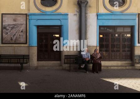 Quelques Algériens âgés s'assoient sur un banc à la gare d'Alger, en Algérie Banque D'Images