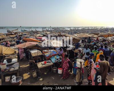 MBour, Sénégal- le 25 avril 2019 : hommes et femmes sénégalais non identifiés du marché aux poissons de la ville portuaire près de Dakar. Il y a des étals de vente et Banque D'Images