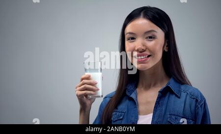 Smiling woman holding verre de lait frais, sans lactose, les produits laitiers, le calcium Banque D'Images