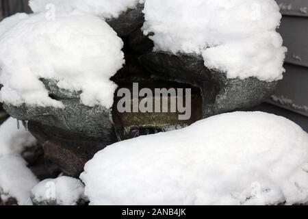 Close up de la neige accumulée sur un éperon rocheux, l'homme a fait une chute d'eau Banque D'Images