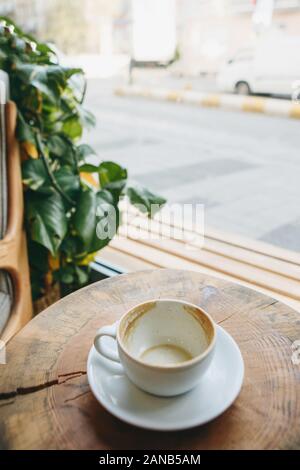 Tasse vide après avoir bu du café sur une table en bois. Concept pour mettre fin à une réunion ou quelque chose d'autre. Banque D'Images