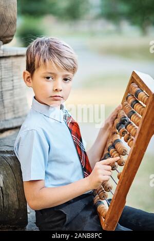 Garçon avec de grandes abacus. À l'aide d'un écolier réfléchi calcul math abacus Banque D'Images