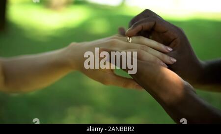 Mariage multiraciale, homme, place de l'anneau d'or sur brides doigt, temps de mariage Banque D'Images