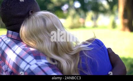 L'Interracial couple embracing, date romantique en parc, bénéficiant d'une vue magnifique Banque D'Images