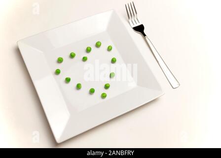 La saine alimentation, les régimes, la nourriture végétarienne et personnes concept - close up avec la fourchette de manger les pois en forme de coeur. Banque D'Images