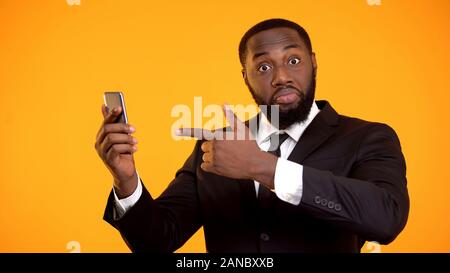 Surpris black businessman sur smartphone, application business cool, shopping Banque D'Images